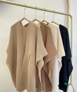 Vertical striped knit texture on chunky V-neck ponchos in khaki, brown, and black