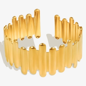 Macro shot of 18k gold irregular vertical bar open bracelet with polished surface finish