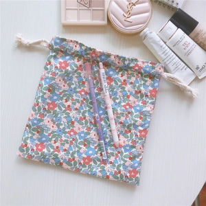 Close-up of floral cotton drawstring pouch with cosmetics for home and travel storage