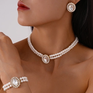 Detail of double-layer pearl jewelry set with oval crystal pendants and sparkling rhinestones