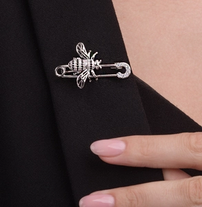 Détail d'une broche abeille en argent avec zircons étincelants sur un revers de costume