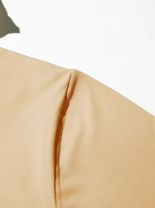 Detail shot of apricot knitted fabric with premium stitching on long sleeve hoodie shirt