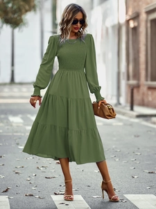 Détail d'une robe midi verte froncée avec ourlet à volants étagés et manches longues