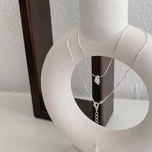 Minimalist 925 sterling silver necklace with drop zircon pendant on white ceramic base