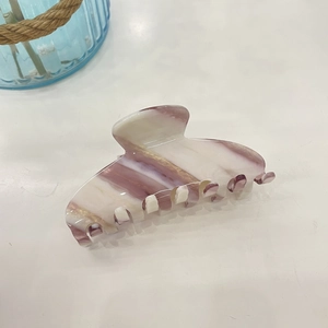 Close-up of purple marble pattern acetate hair claw clip with smooth texture and sturdy teeth