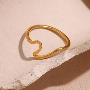 Minimalist 18K gold plated stainless steel wave ring shown on beige stone texture