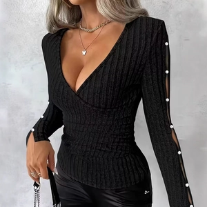 Close-up of black V-neck top showing ribbed knit texture and sleeve pearl decorations