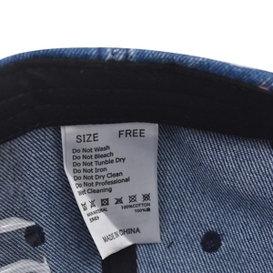 Detail view of cotton baseball cap interior washing label with 100% cotton material spec