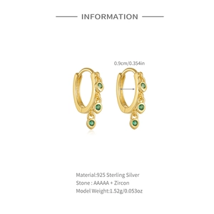 Detailed view of gold 925 sterling silver huggie hoops with green zircon drop pendants