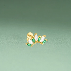 Macro view of gold flower cartilage stud with marquise green and clear cubic zirconia