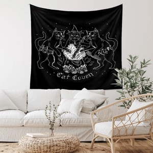 Detailed view of black Cat Coven tapestry with white feline witch line art above a sofa