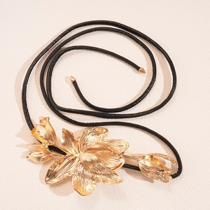 Gros plan du pendentif fleur de tulipe dorée avec cordon en cuir noir et embouts dorés