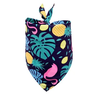 Detail of tropical pet bandana with pink flamingos and pineapples on dark blue fabric