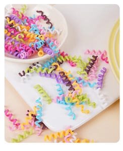 Close-up of colorful spiral hair ties in macaroon colors on a ceramic tray
