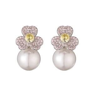 Detail of flower earrings featuring pink pave zircon petals and a large white round pearl