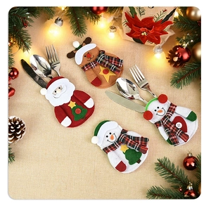 Close-up of Santa, elk, and snowman felt cutlery holders with festive table decorations