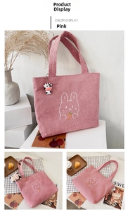 Detail of pink corduroy tote bag with rabbit embroidery and cute plush charm decor