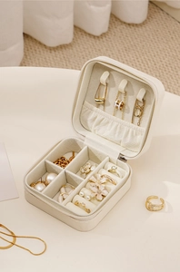Detail view of white leather jewelry box featuring necklace hooks and ring storage slots