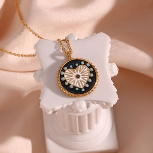 Détail d'un pendentif pièce dorée vintage avec cœur blanc et pois bleu sarcelle