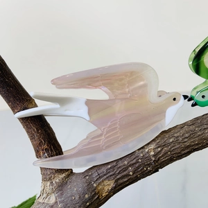 Chic acetate bird claw clip in peach marble texture perched on a wooden branch