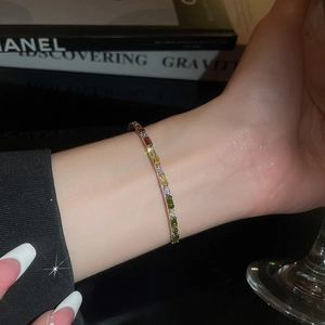 Close-up of elegant gold-plated bracelet with multi-colored rectangular crystals