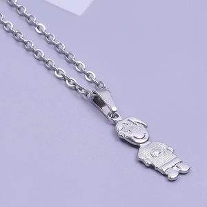 Macro shot of silver stainless steel pendant featuring a minimalist smiling boy silhouette