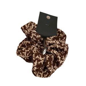 Elegant floral print hair scrunchie in brown and beige fabric for stylish hair styling