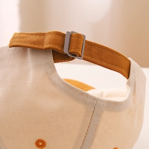 Detail view of cotton baseball cap with adjustable strap and metal buckle closure