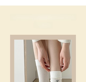 Détail de chaussettes blanches en maille avec nœuds noirs au style ballet et doux