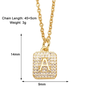 Macro shot of gold square pendant with letter A and cubic zirconia on link chain