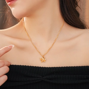 Close-up of elegant gold Pegasus pendant pearl necklace worn by a model in soft lighting