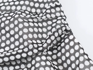 Detail shot of vintage black fabric with white polka dots and soft chiffon texture