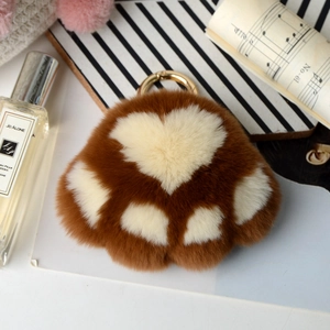 Detail of brown faux fur bear paw keychain with soft plush texture and golden metal clasp