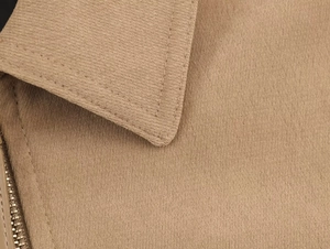 Détail des coutures précises et texture sergé sur le revers kaki et zip en métal