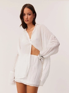 Two-piece white long-sleeved shirt and mini skirt set with pleated texture and relaxed fit