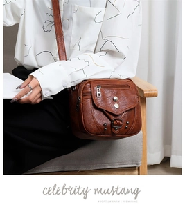 Détail du sac bandoulière vintage marron en cuir souple avec rivets et bandoulière réglable