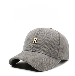 Detail of grey herringbone baseball cap featuring a premium 3D gold metal R logo