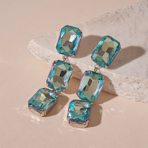Detail of square gradient crystal earrings with gold finish and tassel drops