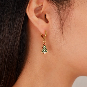 Christmas tree earrings with colorful enamel charms in gold finish worn by a model