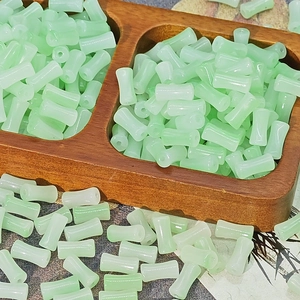 Macro view of translucent light green bamboo-shaped glass beads for DIY jewelry making