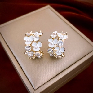 Elegant C-shaped flower stud earrings with white enamel, pearls, and zircons on gold base