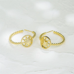 14K gold plated geometric round earrings with beaded texture and star cutouts on marble
