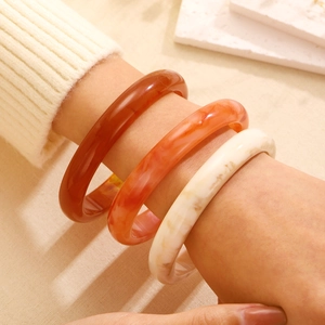 Three-piece set of retro marble pattern acrylic bangles in amber, orange, and cream white