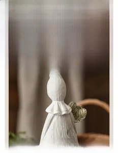 Detail of vintage ivory resin rabbit ornament showing wood-like texture and green leaf detail
