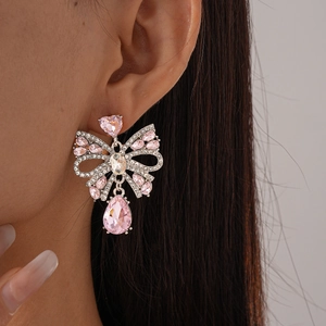 Gros plan de boucles d'oreilles nœud en cristal rose avec pierres poires et zircons brillants