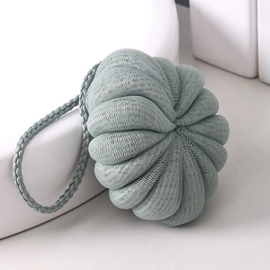 Sage green mesh loofah sponge in pumpkin shape with a braided hanging rope for bathing