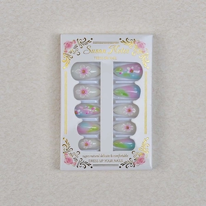 Detail of almond-shaped press-on nails with 3D flower carvings and soft color gradient