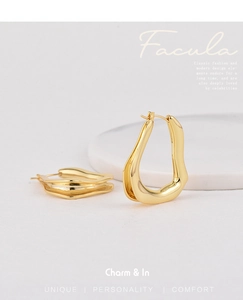 Close-up of gold-plated irregular wavy earrings with liquid metal texture on white stand