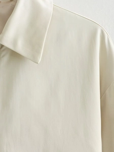 Dettaglio del colletto della giacca beige che mostra la trama del tessuto twill
