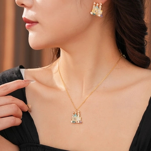 Detailed view of gold plated castle necklace and earrings set featuring colorful gemstones